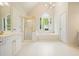 Bright bathroom featuring a soaking tub under an arched window and a glass shower at 510 Morning Mist Ct, Alpharetta, GA 30022