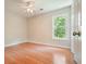 Bright bedroom with hardwood floors and a window offering a view of lush greenery at 510 Morning Mist Ct, Alpharetta, GA 30022