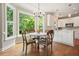 Charming dining area with ample natural light, hardwood floors, a view of the white kitchen, and yard at 510 Morning Mist Ct, Alpharetta, GA 30022