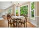 Cozy dining area featuring a round table set, large windows offering backyard views, and hardwood floors at 510 Morning Mist Ct, Alpharetta, GA 30022