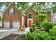 Beautiful brick home featuring a bright red front door, white garage doors and meticulously landscaped front yard at 510 Morning Mist Ct, Alpharetta, GA 30022