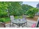 Outdoor patio with round table and seating, surrounded by lush greenery and trees at 510 Morning Mist Ct, Alpharetta, GA 30022