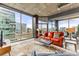 Bright living room features floor-to-ceiling windows and a comfortable red leather sofa at 943 Peachtree Ne St # 1708, Atlanta, GA 30309