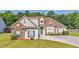 Charming two-story home with a well-manicured lawn, attached garage, green door and lush landscaping at 127 Autumn Run Pl, Villa Rica, GA 30180