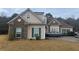 Charming single-Gathering home with brick and vinyl siding, complemented by green shutters and a well-manicured lawn at 127 Autumn Run Pl, Villa Rica, GA 30180