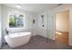 Bathroom with a sleek tub, walk-in shower, and large window offering plenty of natural light at 1342 Carter Rd, Decatur, GA 30030