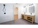 Bright bathroom with marble walls, gray tile floors, double sink vanity, and a glass shower at 1342 Carter Rd, Decatur, GA 30030