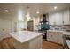 Open concept kitchen features white cabinetry, stainless steel appliances, island with quartz countertops, and hardwood floors at 1342 Carter Rd, Decatur, GA 30030