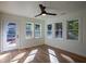 Bright and airy sun room with hardwood floors, ceiling fan, and lots of windows offering a view to the outdoors at 1342 Carter Rd, Decatur, GA 30030