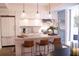 Modern kitchen with sleek white cabinets, a stylish island with seating, and stainless steel appliances under pendant lights at 1820 Peachtree Nw St # 309, Atlanta, GA 30309