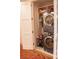Stacked washer and dryer setup with shelving in laundry closet at 1820 Peachtree Nw St # 309, Atlanta, GA 30309