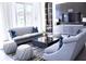 Bright living room features a gray couch, accent pillows, coffee table, and large windows at 1820 Peachtree Nw St # 309, Atlanta, GA 30309