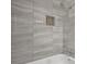 Close up on bath surround featuring a tiled shampoo niche and shower head at 2636 Flagstone Se Dr, Atlanta, GA 30316