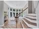 Sunlit foyer with hardwood floors, staircase, and dining area with curved window wall at 3860 Overlake Dr, Cumming, GA 30041