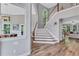 Spacious foyer featuring staircase, hardwood floors, and views into the dining and living areas at 3860 Overlake Dr, Cumming, GA 30041