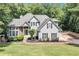 Large home with gray siding, stone accents, dark shutters, and a manicured lawn at 3860 Overlake Dr, Cumming, GA 30041