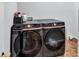 Modern laundry room featuring high-end front loading washer and dryer units, and tiled flooring at 3860 Overlake Dr, Cumming, GA 30041