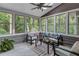 Bright sunroom boasting many windows with wooded views, cozy seating, and a ceiling fan at 3860 Overlake Dr, Cumming, GA 30041