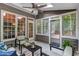 Inviting sunroom featuring a ceiling fan, patio access, and wooded view from many windows at 3860 Overlake Dr, Cumming, GA 30041