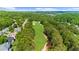 Aerial view of a lush green golf course surrounded by trees and residential houses at 7049 Bennington Ln, Cumming, GA 30041
