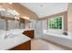 This bathroom features a double sink vanity, a tub, and a walk-in shower with glass doors at 7049 Bennington Ln, Cumming, GA 30041