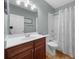 Bright bathroom featuring a cherry vanity, white counter tops, tub with shower, and hardwood floors at 7049 Bennington Ln, Cumming, GA 30041