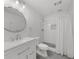 Modern bathroom featuring a walk-in shower and white vanity with a stylish round mirror at 7049 Bennington Ln, Cumming, GA 30041