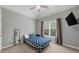This bedroom features neutral walls, a ceiling fan, and a window for natural light at 7049 Bennington Ln, Cumming, GA 30041