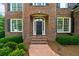 Inviting front entrance with brick steps, arched entryway, and a well-manicured garden at 7049 Bennington Ln, Cumming, GA 30041