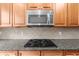 Updated kitchen showcasing granite counters, a gas range, and stainless steel microwave at 7049 Bennington Ln, Cumming, GA 30041