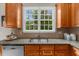 Granite countertops and tiled backsplash accent the sink in this warm and inviting kitchen at 7049 Bennington Ln, Cumming, GA 30041