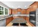 Spacious kitchen with an island, wooden cabinets, stainless appliances, and hardwood floors at 7049 Bennington Ln, Cumming, GA 30041