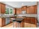 Well-appointed kitchen features wooden cabinetry, granite countertops, and stainless steel appliances at 7049 Bennington Ln, Cumming, GA 30041
