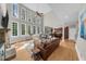 Open-concept living room with tall ceilings, fireplace, hardwood flooring, and an abundance of natural light at 7049 Bennington Ln, Cumming, GA 30041