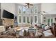 Spacious living room with hardwood flooring, fireplace, and many bright windows to the rear yard at 7049 Bennington Ln, Cumming, GA 30041