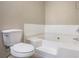 Bathroom featuring a tiled bathtub and a toilet with neutral colored walls at 1932 Sawgrass Dr, Hampton, GA 30228