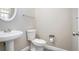 Practical half bathroom with a pedestal sink, toilet, and a neutral wall color at 1932 Sawgrass Dr, Hampton, GA 30228