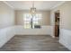 Dining area features wainscoting, modern light fixture, wood-look floors, and connects to kitchen at 1932 Sawgrass Dr, Hampton, GA 30228