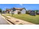 Two-story house boasts a spacious yard with a storage shed, great curb appeal, and sidewalk at 1932 Sawgrass Dr, Hampton, GA 30228