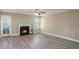 Cozy living room showcases a fireplace, wood floors, fan, and neutral color palette, creating a warm ambiance at 1932 Sawgrass Dr, Hampton, GA 30228