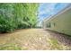 Spacious backyard with a partial view of the home's exterior and lush green trees at 2557 Woodford Ln, Buford, GA 30519