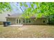 View of the home's backyard, featuring a patio, lawn, and wooded surroundings at 2557 Woodford Ln, Buford, GA 30519