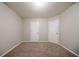 Bedroom with two doors, neutral walls, trim, and carpeting at 2557 Woodford Ln, Buford, GA 30519