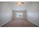 This bedroom features neutral walls, plush carpeting, and a ceiling fan, creating a cozy and inviting atmosphere at 2557 Woodford Ln, Buford, GA 30519