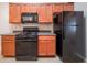 Modern kitchen featuring a gas range, black appliances, dark countertops, and ample cabinet space at 2557 Woodford Ln, Buford, GA 30519