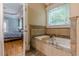 Bathroom features a soaking tub with tile surround and a view into the main bedroom at 3044 Dogwood Dr, Atlanta, GA 30354