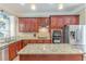 Gourmet kitchen featuring cherry cabinets, granite countertops, and stainless steel appliances at 3044 Dogwood Dr, Atlanta, GA 30354