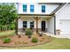 Inviting front porch with seating and landscaped garden, leading to the entrance of this lovely home at 165 Brookstone E Park, Acworth, GA 30101