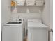 Efficient laundry room with white washer and dryer, plus overhead storage at 165 Brookstone E Park, Acworth, GA 30101
