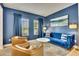 Stylish living room boasts a blue velvet sofa and tan leather chairs with modern decor at 165 Brookstone E Park, Acworth, GA 30101